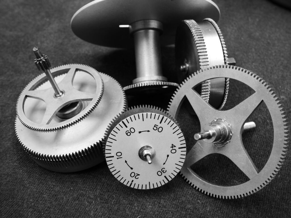 Detailed black and white image of various metal gears in a mechanical setup.