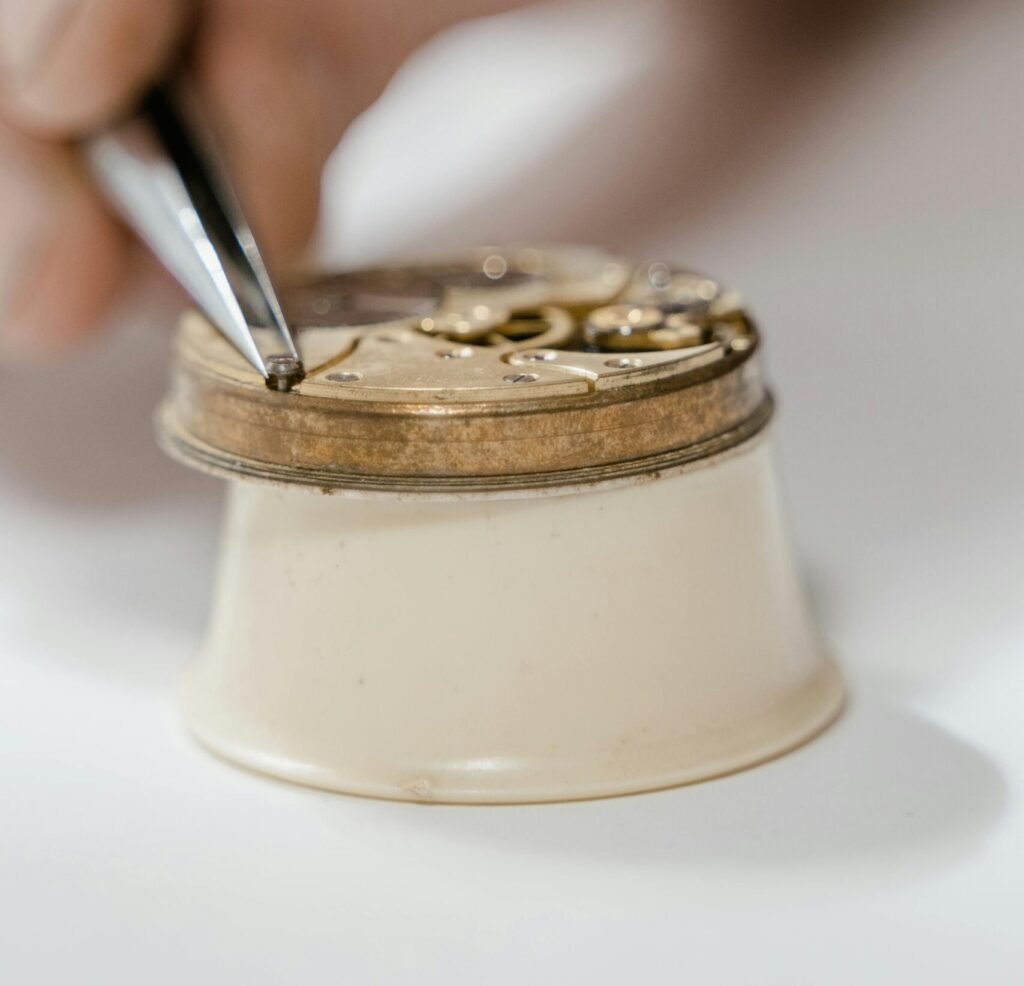 Detailed shot of a watchmaker fixing a timepiece with precision tools.